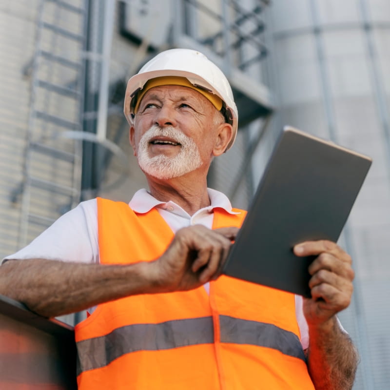 Man wearing high vis reviewing tablet