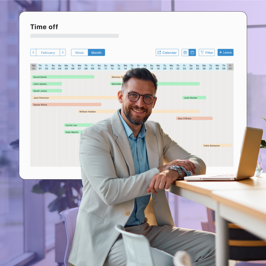 Business owner sitting at table with leave management software in background