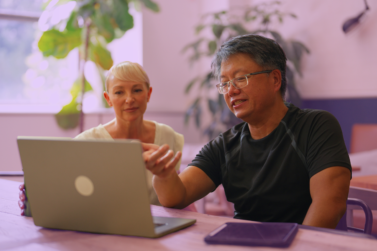 Colleagues using HR performance management software on laptop