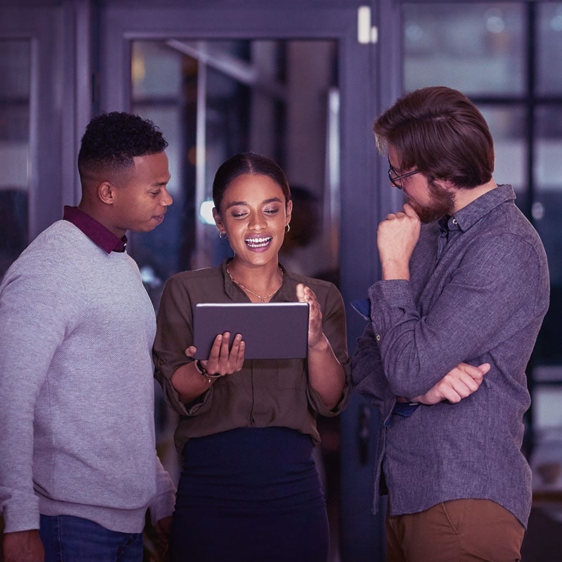 Three colleagues looking over a single tablet