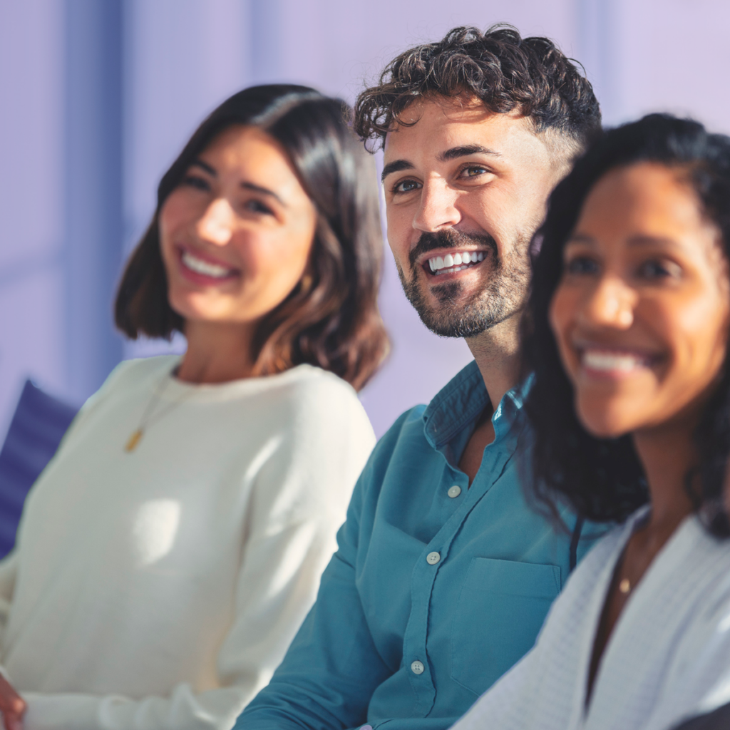 Three smiling colleagues sitting together