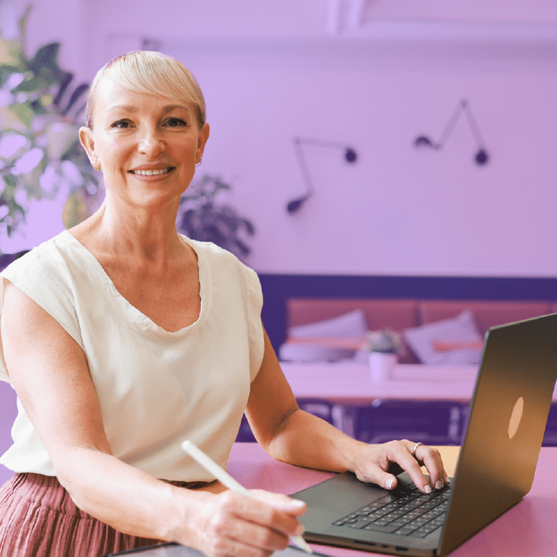 HR manager taking down notes while using a laptop