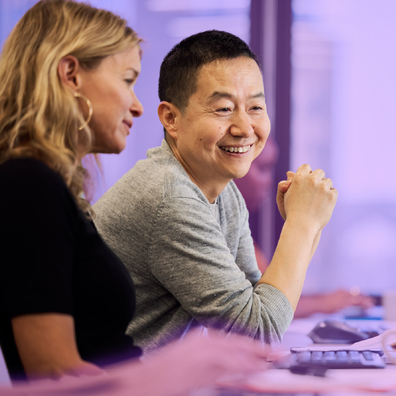 Two colleagues chatting at a desk