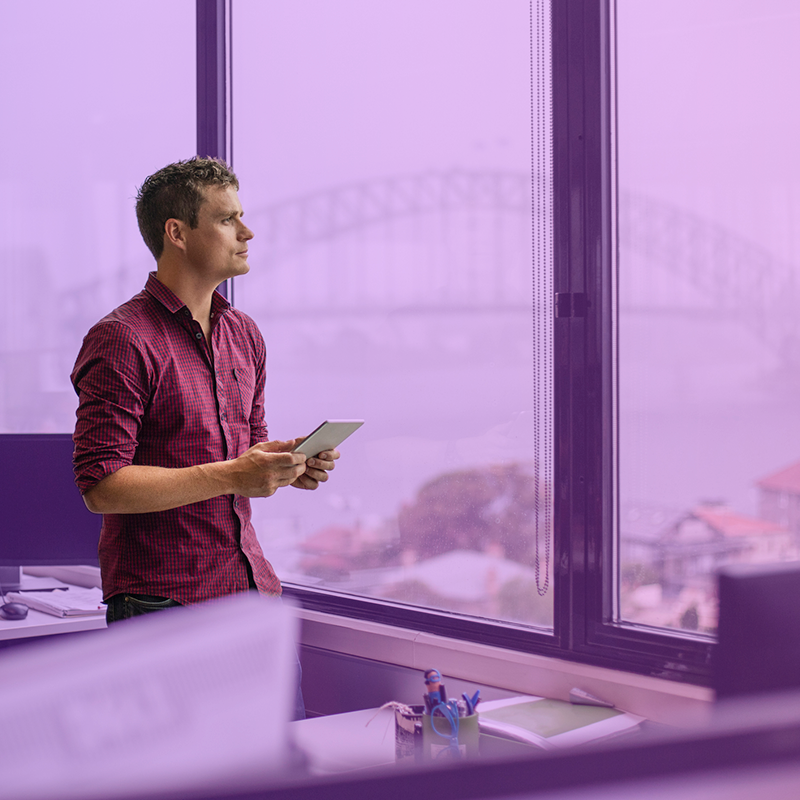 Business owner in office overlooking Sydney Harbour