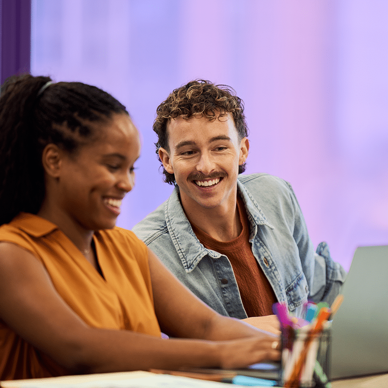 Man and woman working together in front of laptop