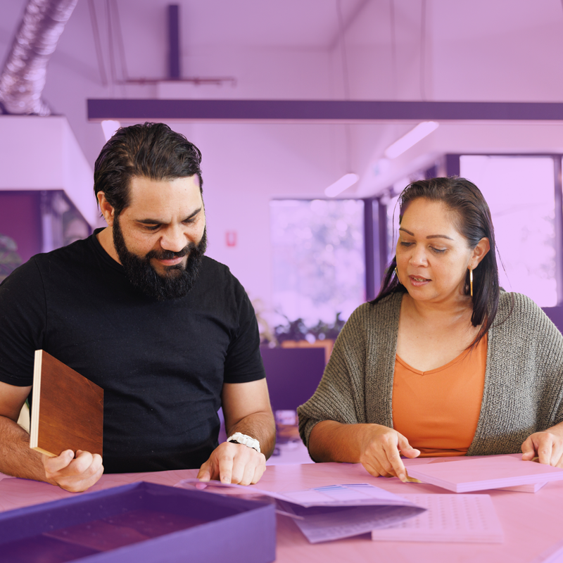 Two colleagues reviewing documents at a desk