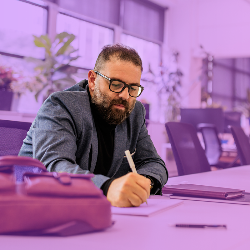 Businessman writing notes in modern office setting