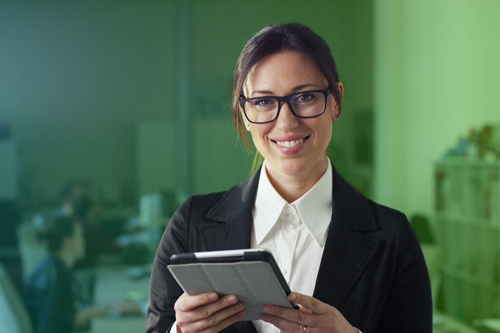Smiling woman holding a tablet in an office setting