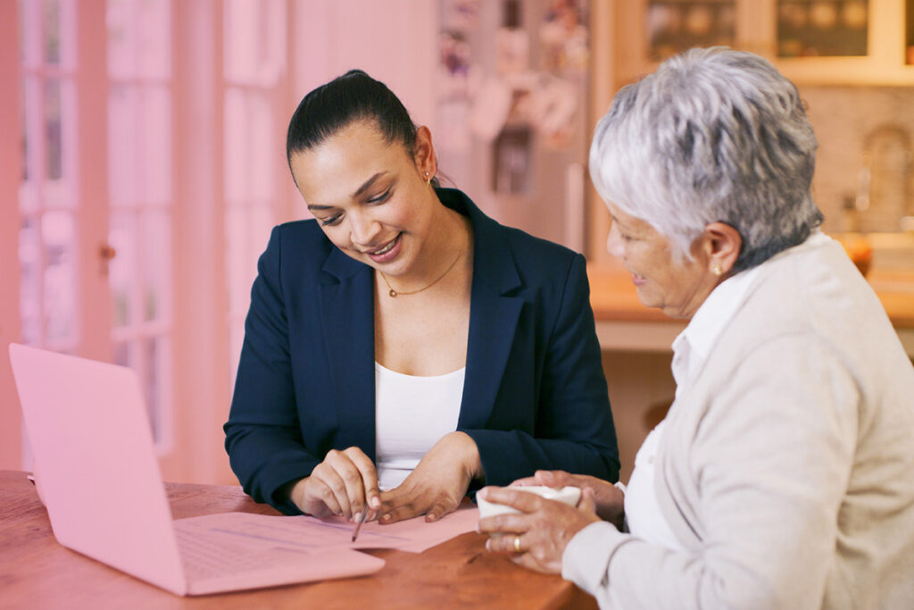 Two colleagues sitting at a desk reviewing documents together in an office