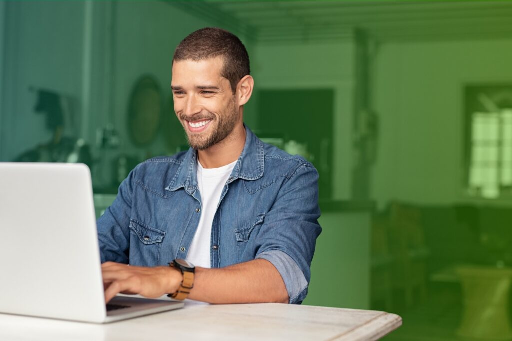 Smiling man using a laptop