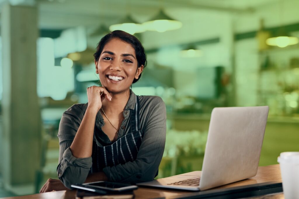 Smiling woman sitting in front of laptop