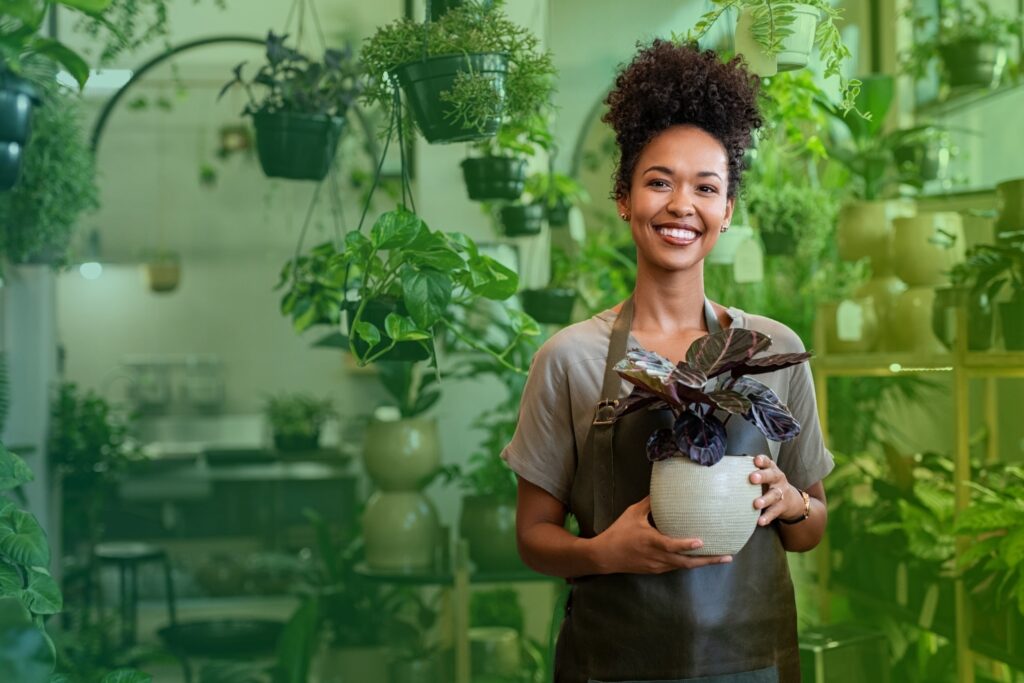 Smiling woman holding a potted plant
