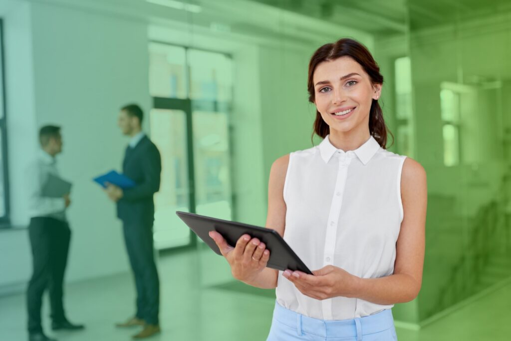 Smiling woman holding a tablet in an office setting