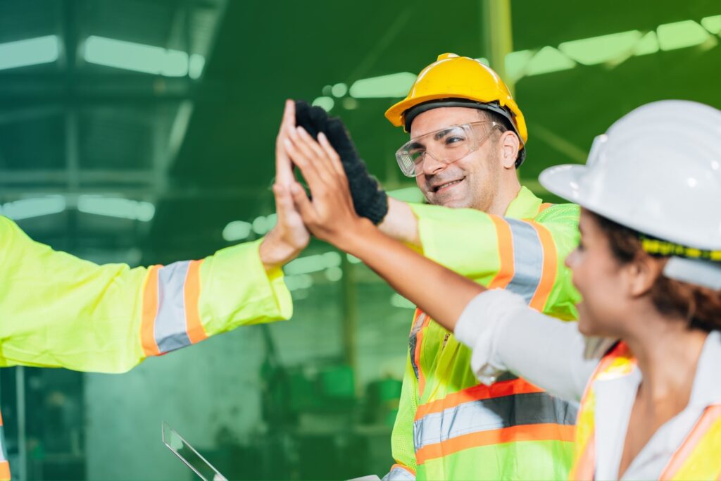 Colleagues in hard hats high-fiving