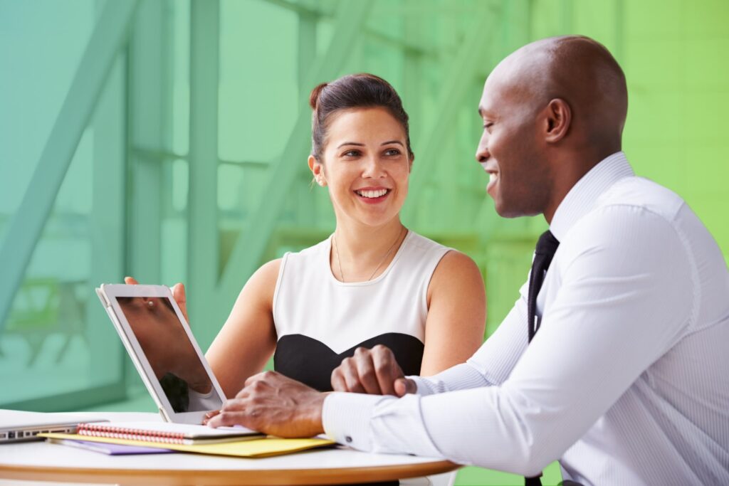 Smiling colleagues chatting at a desk