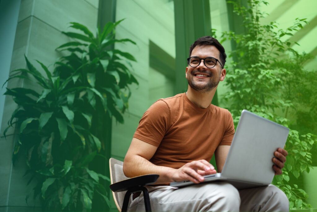 Smiling man using a laptop in an office setting