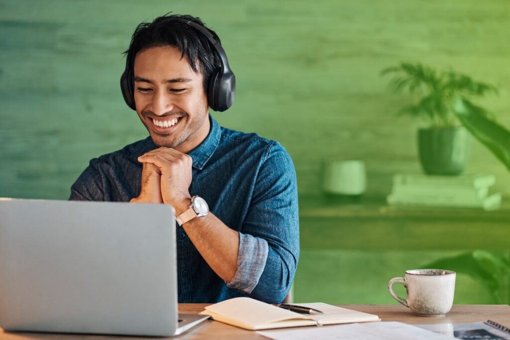 Smiling man sitting in front of laptop
