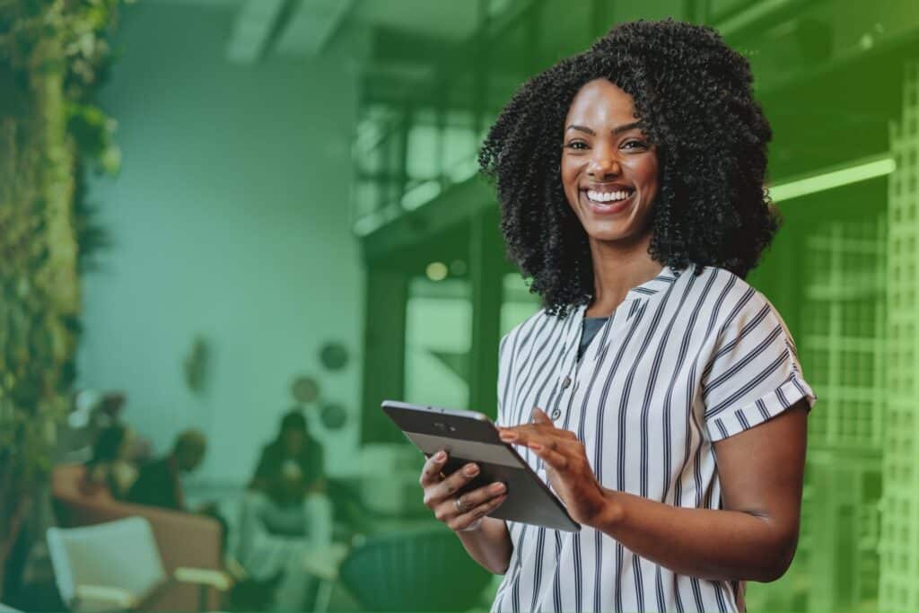 Smiling woman holding a tablet in an office setting