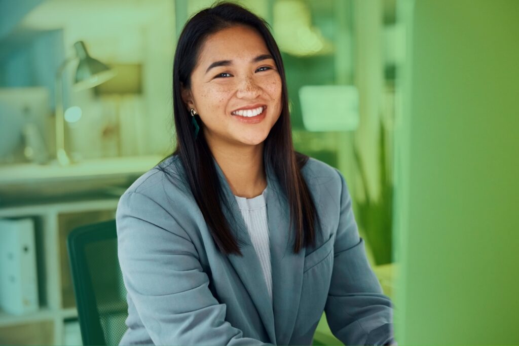 Smiling woman sitting in front of laptop