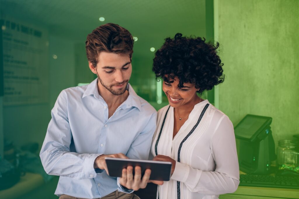 Two colleagues chatting while one holds a tablet