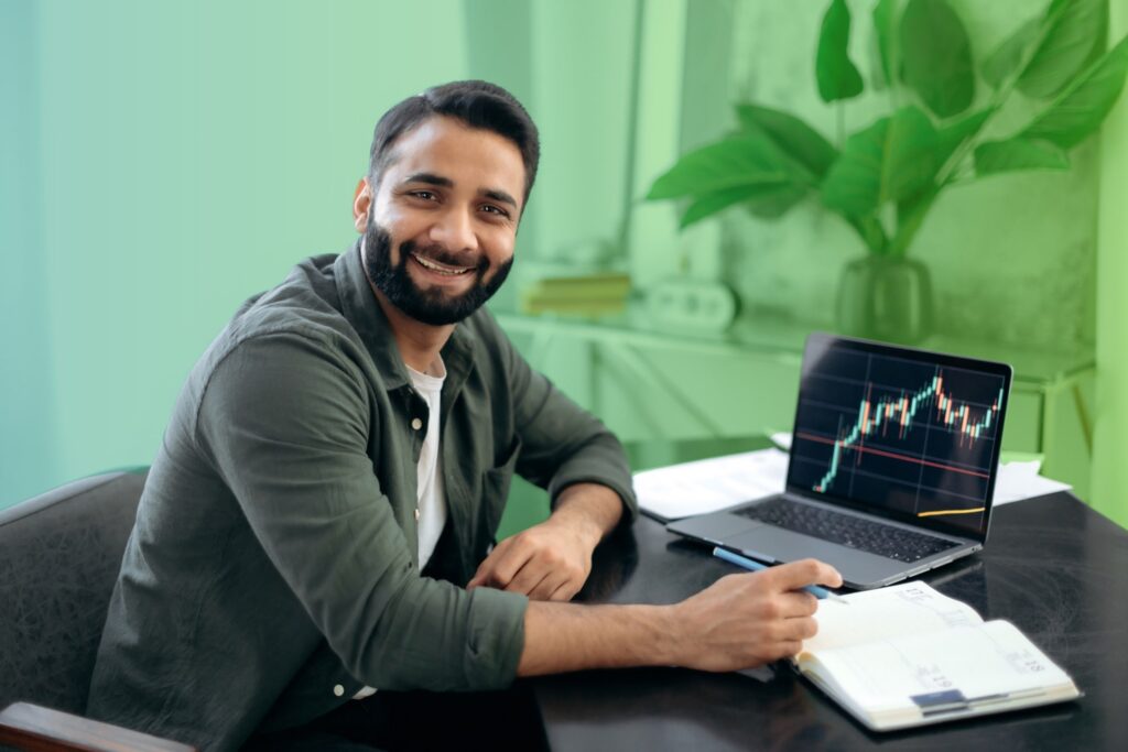 Smiling man using a laptop in an office setting