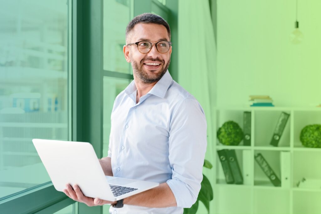 Businessman smiling while carrying a laptop
