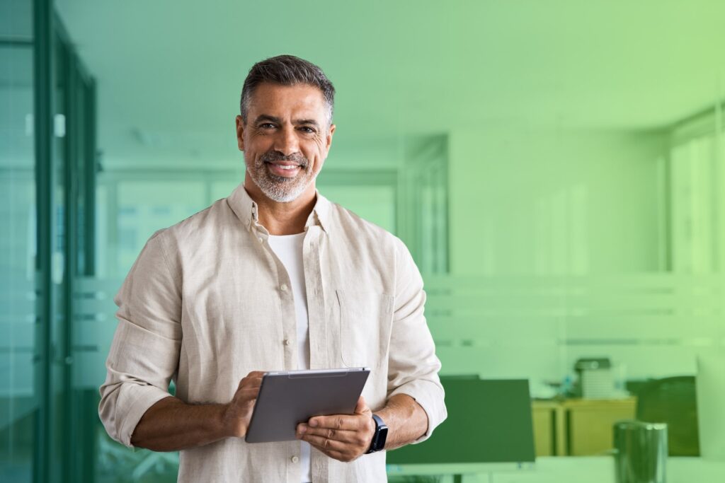 Smiling man holding a tablet in an office setting
