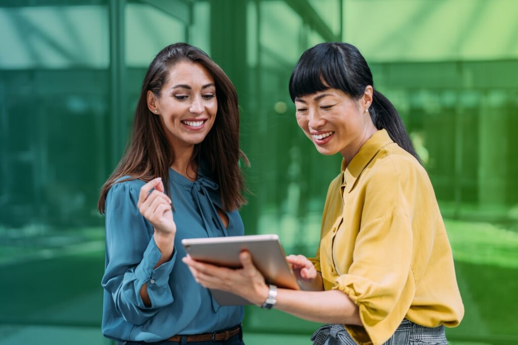 Smiling women holding a tablet in an office setting