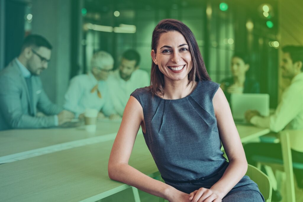 Businesswoman smiling while sitting at a table during a meeting