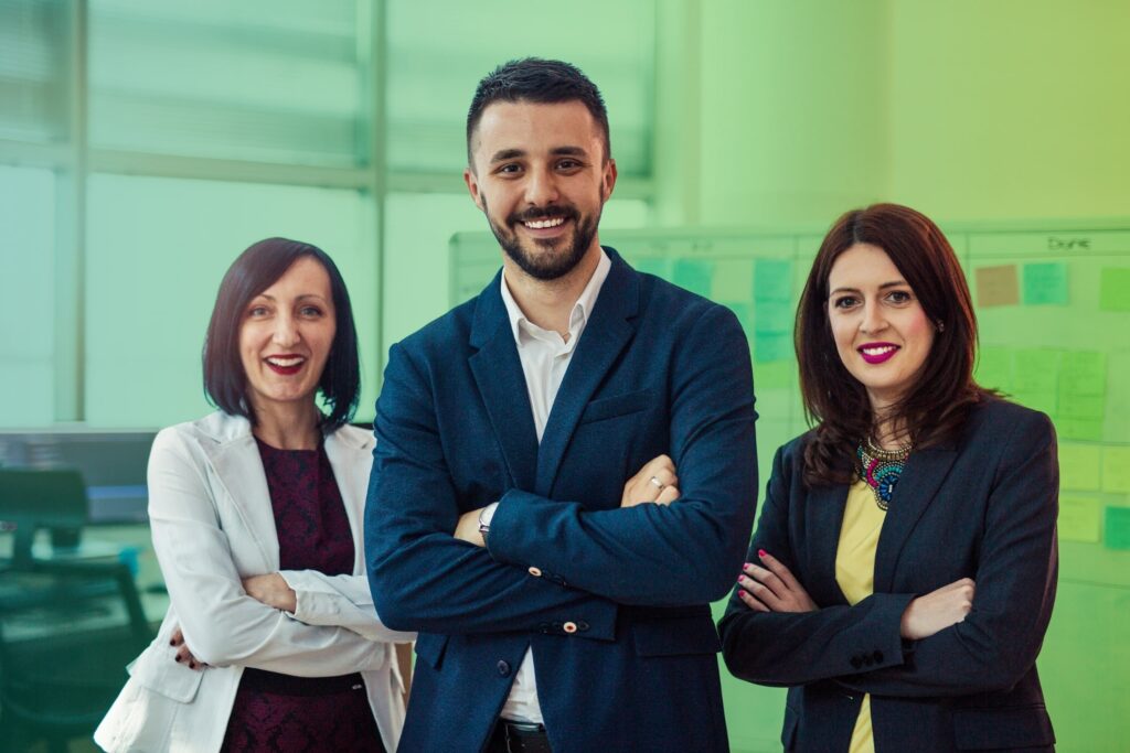 Three colleagues smiling with arms crossed