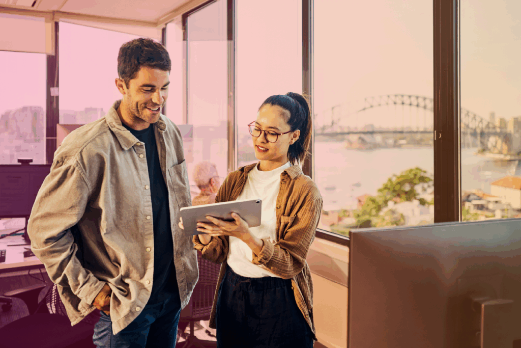 Two colleagues chatting while one holds a tablet