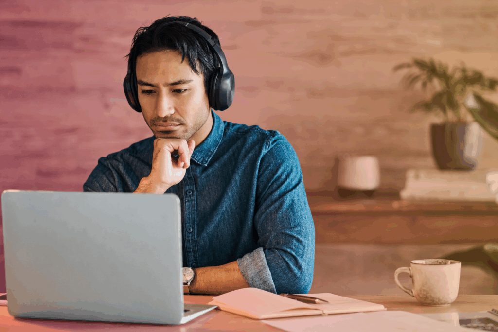 Man using a laptop while wearing headphones